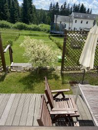 Terrasse mit Sitzmöbeln,Sonnenschirm,Box für die Sitzauflagen und dazugehöriger Liegewiese mit Sandkasten ( Sandspielsachen und Liegestühle,Grill und Zubehör befinden sich in der Garage,in welcher auch die Fahrräder sicher verwahrt werden können) - Bild 16: Ferienwohnung Fischer „Am Greifenbachstauweiher“