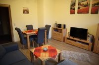 Wohnzimmer mit Essecke,Schränken,Fernseher und Radio mit CD-Player,es sind weiterhin eine Auswahl für große und kleine Gäste vorhanden - Bild 1: Ferienwohnung Fischer „Am Greifenbachstauweiher“